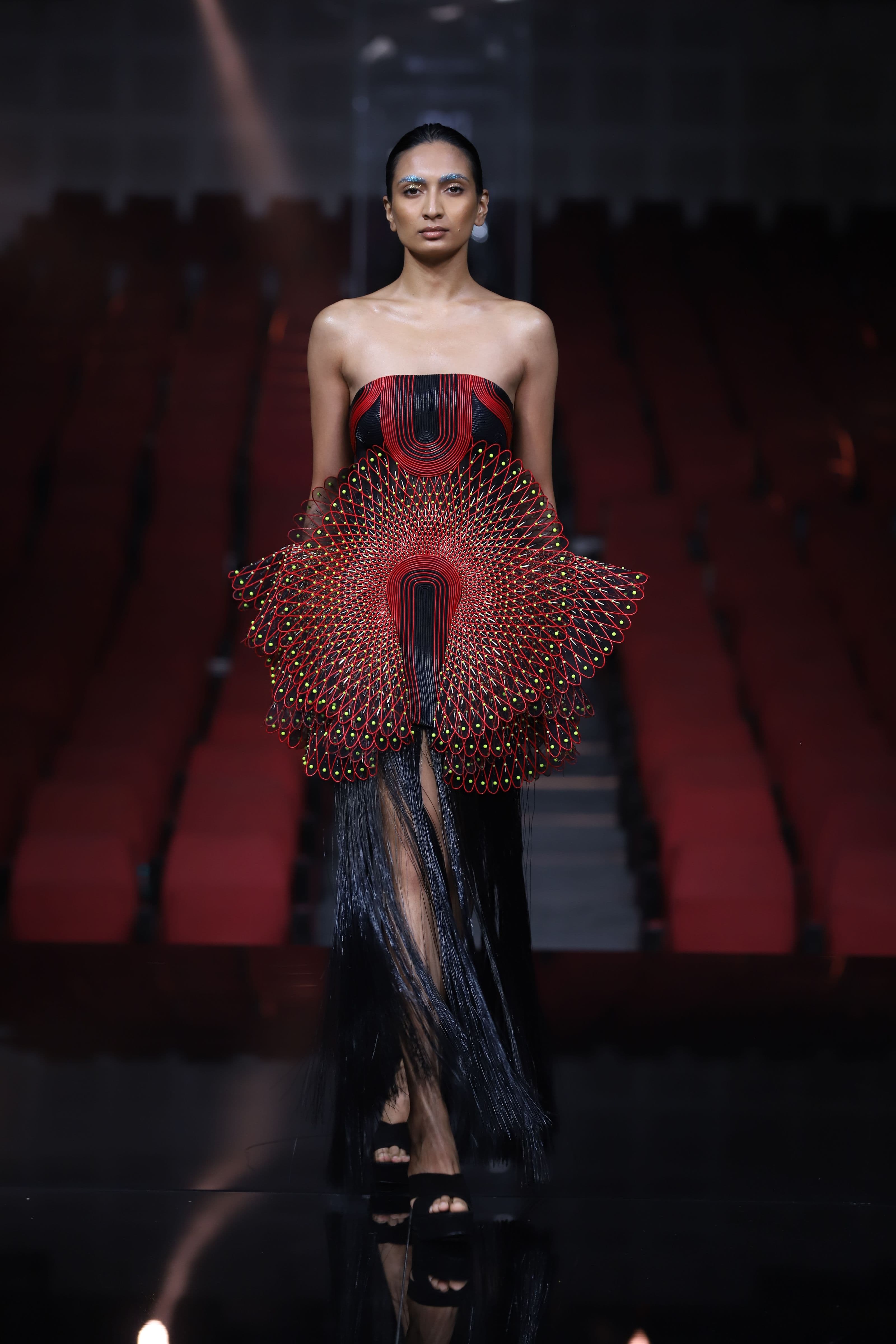 Artist on a runway under dramatic show lighting