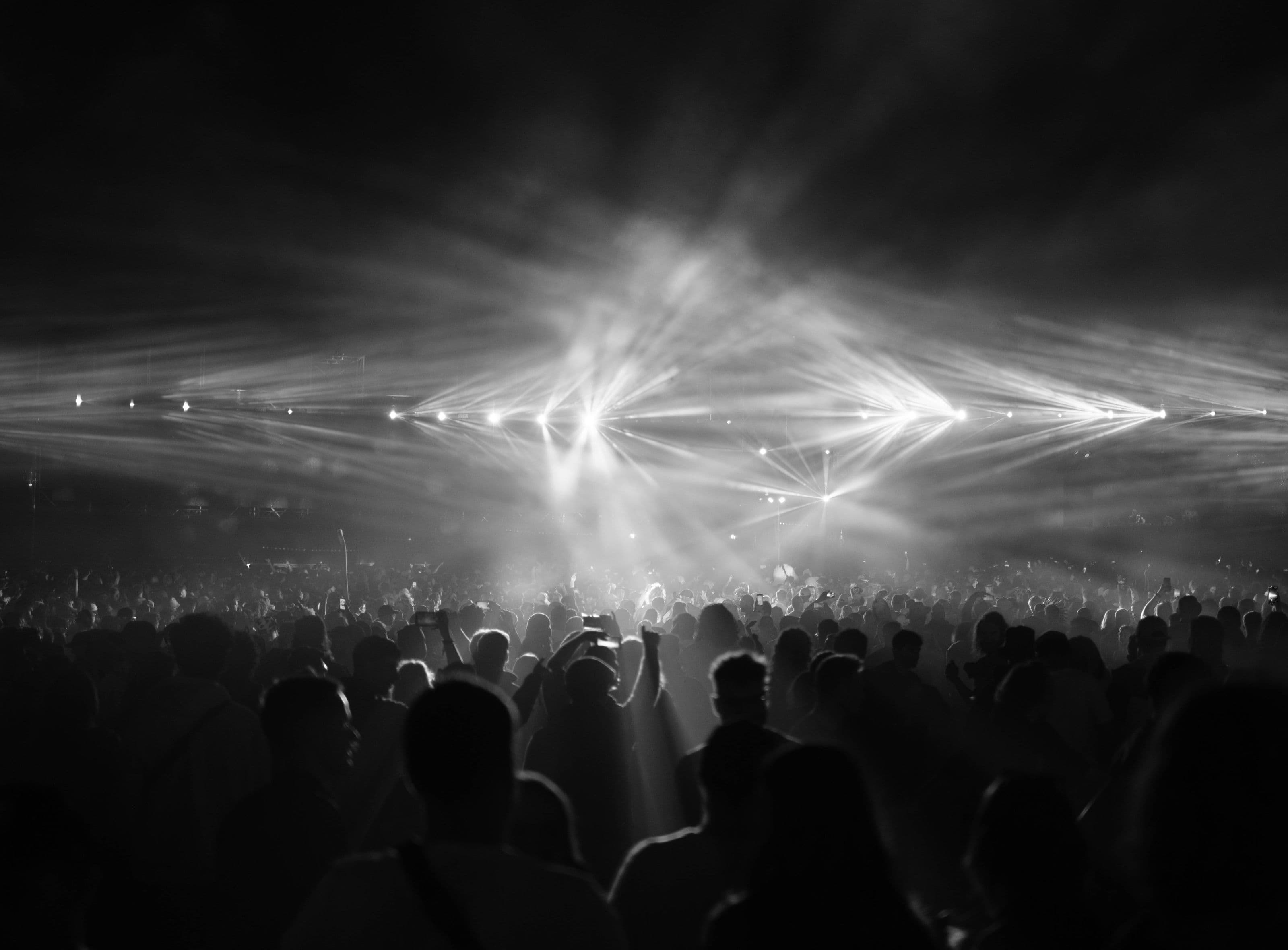 A festival crowd at night lit by stage lighting
